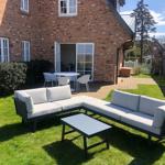 Backyard with garden furniture and terrace in front of brick house