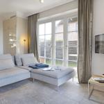 Living room with sofa, TV, and window to outdoor terrace.