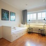 Room with double bed, bunk bed, window, and wall art.