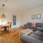Living and dining area with sofa, dining table, and wooden floor.