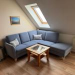 A living room with blue sofa, wooden table, and skylight.