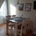 Dining area with table, four chairs, and pendant light.