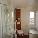 Bathroom with shower, toilet, and washing machine.