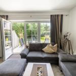 Wohnzimmer mit Sofa, Sitzbank und Terrassentür.