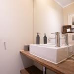 Sink with two faucets on wooden vanity