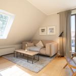 Living room with sofa, coffee table, and view of balcony.