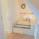 Schlafzimmer mit Dachschrägen, Bett und Wandspiegel