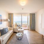 Living room with sofa, armchair, and sea view