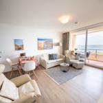 Living room with sea view and integrated dining area.