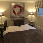 Schlafzimmer mit Bett, zwei Nachttischen und Wandbild