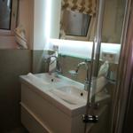 Badezimmer mit Doppelwaschbecken, Spiegel und Dusche.