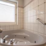 Eine Badewanne mit Duschkopf und Fenster