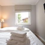 Schlafzimmer mit Bett, Fenster und Fernseher.