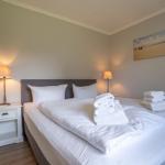 Schlafzimmer mit Bett, Nachttisch und Wandbild.