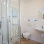 Badezimmer mit Dusche, Toilette und Waschbecken.