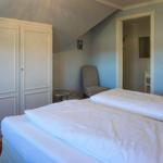 Zimmer mit Doppelbett, Kleiderschrank und Sessel