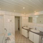 Bathroom with shower, bathtub, two sinks, and mirror.