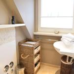 Badezimmer mit Waschbecken, Dusche und Fenster.