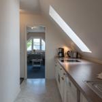 Küche mit Dunstabzug, Kaffeemaschine und Blick in Wohnzimmer