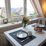 Tisch mit Platz für zwei, Blumen und Blick auf Dächer.