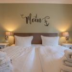 Bedroom with double bed, nightstands, and wall decor.