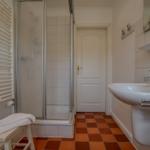 Bathroom with shower, sink, and heater.
