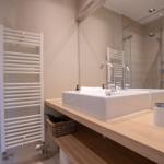 Badezimmer mit Waschbecken, Spiegel und Dusche