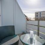 Terrace with chair and table. Background: buildings and fence.
