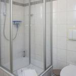 Shower with glass enclosure, toilet, and towel in bathroom