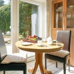 Round dining room with table, chairs, and garden view.