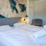 Bedroom with bed, fish mural on wall, and chair.