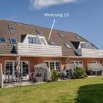 Wohnung 13 mit Balkon, Terrasse und Garten. Mehrere Fenster und Dachgauben.