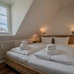 Schlafzimmer mit Doppelbett, Fenster und Holzboden