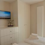 Schlafzimmer mit TV, Kleiderschrank und Fenster