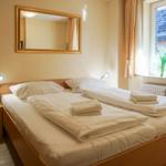 Schlafzimmer mit Doppelbett, Spiegel und Fenster mit Blick.