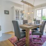 Esszimmer mit Holztisch, Stühlen und Kamin