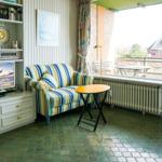Living area with sofa, TV, and view of balcony