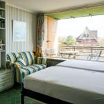 Two beds, sofa, TV, and balcony with sea view.