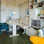 Dining area with bench, glass table, and blue chair. Living area with sofa and TV.
