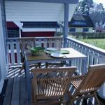 Terrasse mit Tisch und Stühlen, Blick auf Garten und Häuser.