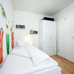 Schlafzimmer mit Einzelbett und Etagenbett