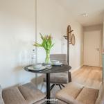 Dining area with round table, three chairs, and flower bouquet