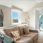 Living room with sofa, table, and sea view.