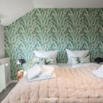 Bedroom with patterned wall, bed, and window.