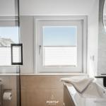 Bathroom with window, sink, and mirror.