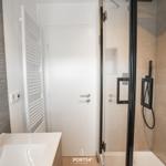 Bathroom with shower, sink, and heater.
