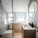 Modern bathroom with shower, sink, and window with sea view.