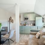 Living and kitchen area with sofa, dining table, and kitchenette.