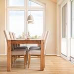 Esszimmer mit Holztisch, Stühlen und großem Fenster zur Aussicht.