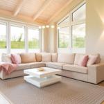 Wohnzimmer mit großem Sofa, weißen Fenstern und Holzdecke.
